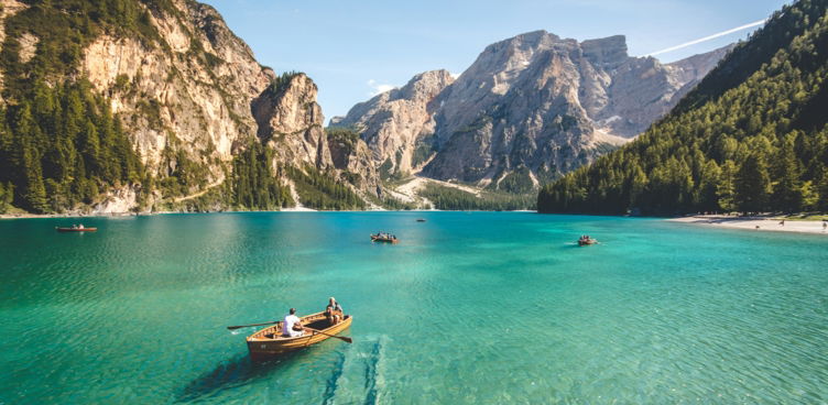 three brown wooden boat on blue lake water taken at daytime